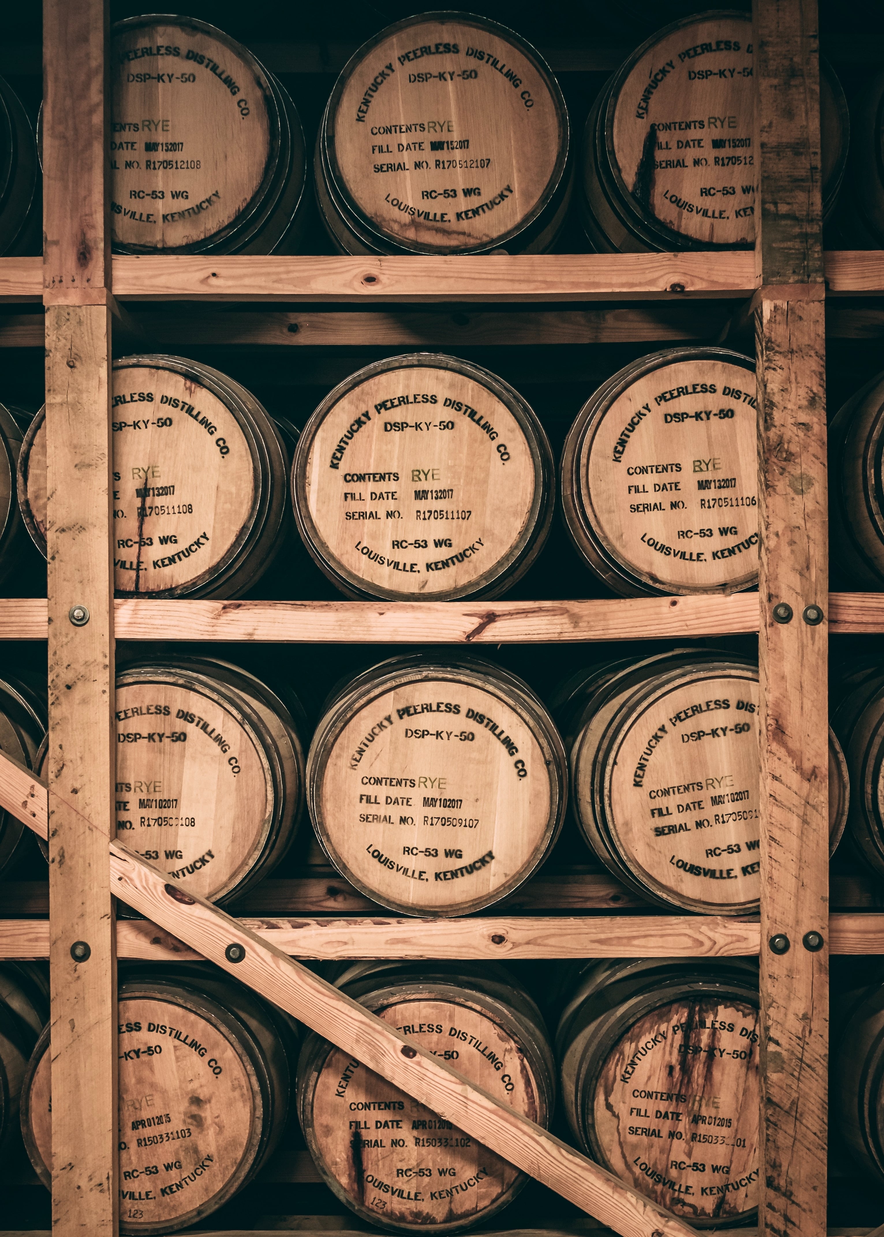 Rows of oak whisky casks aging in a warehouse