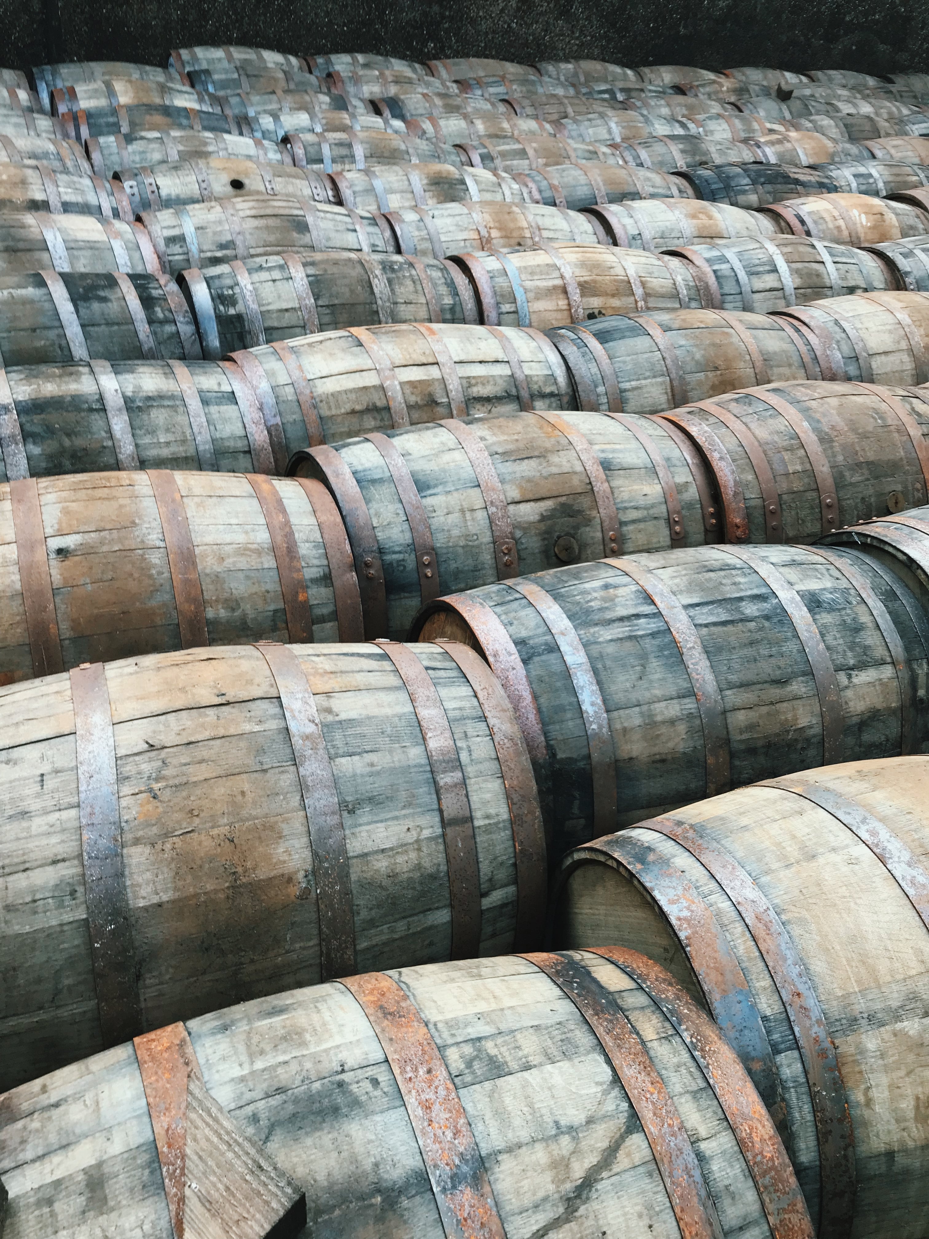 Stacked whisky barrels filling a warehouse aisle