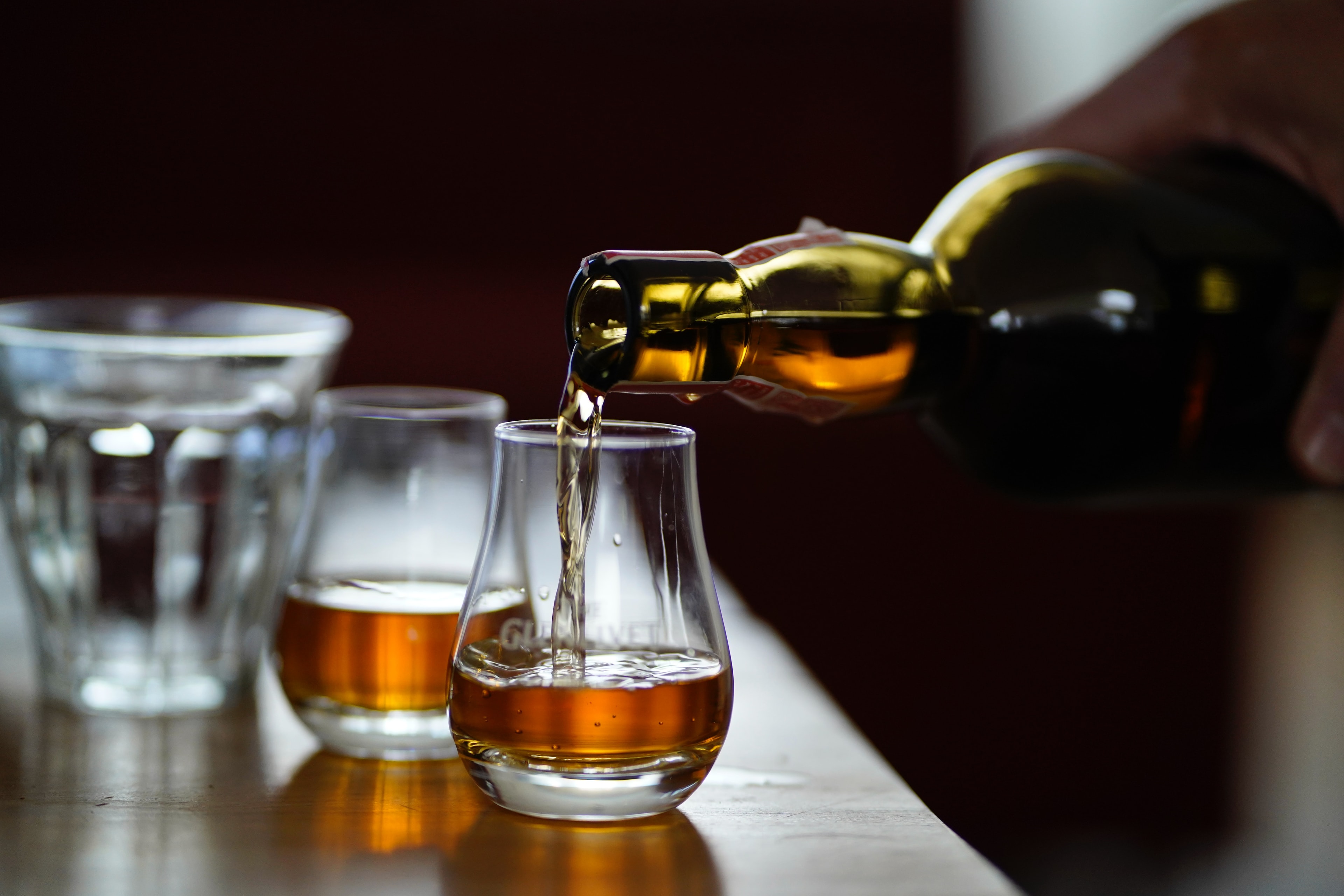 Whisky poured from a bottle into a tasting glass