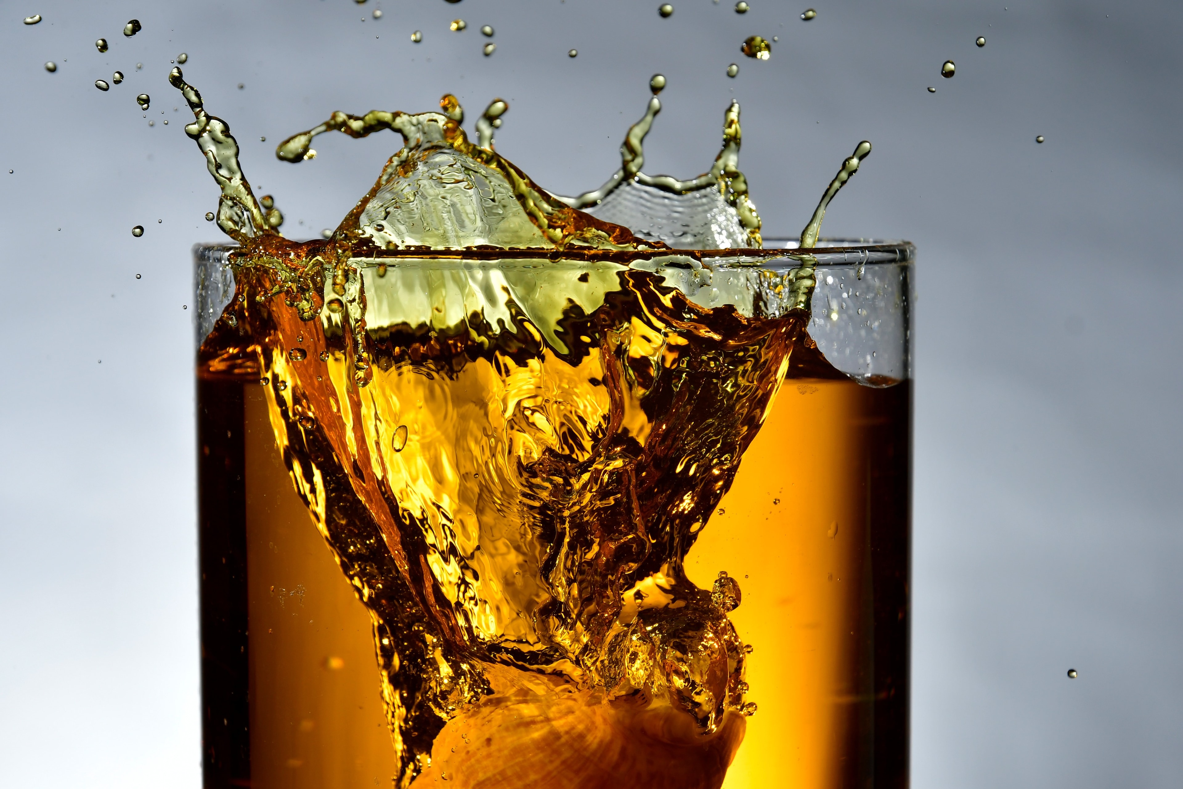 Whisky splashing dramatically from a glass