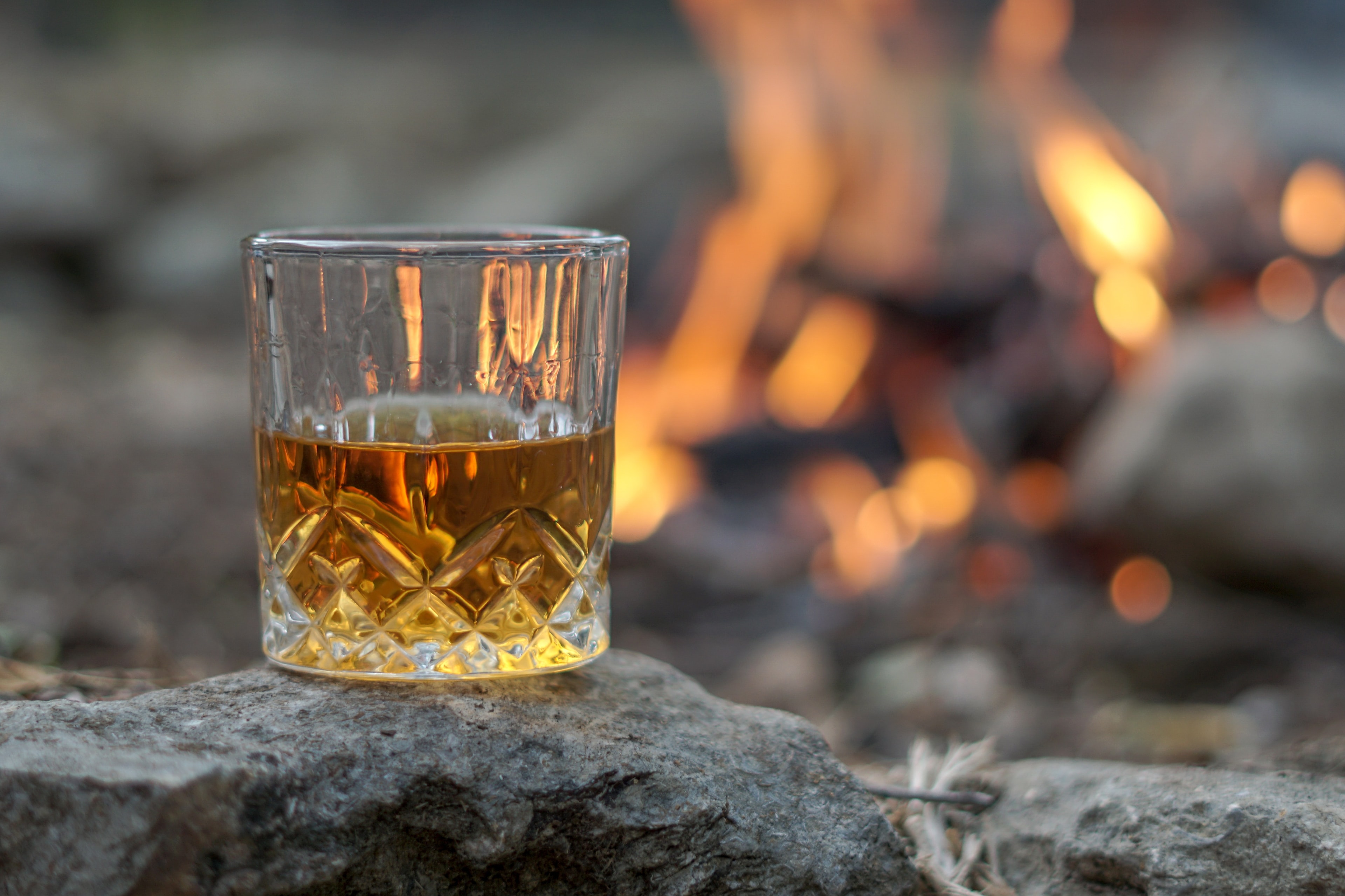 Whisky glass lit beside a fire