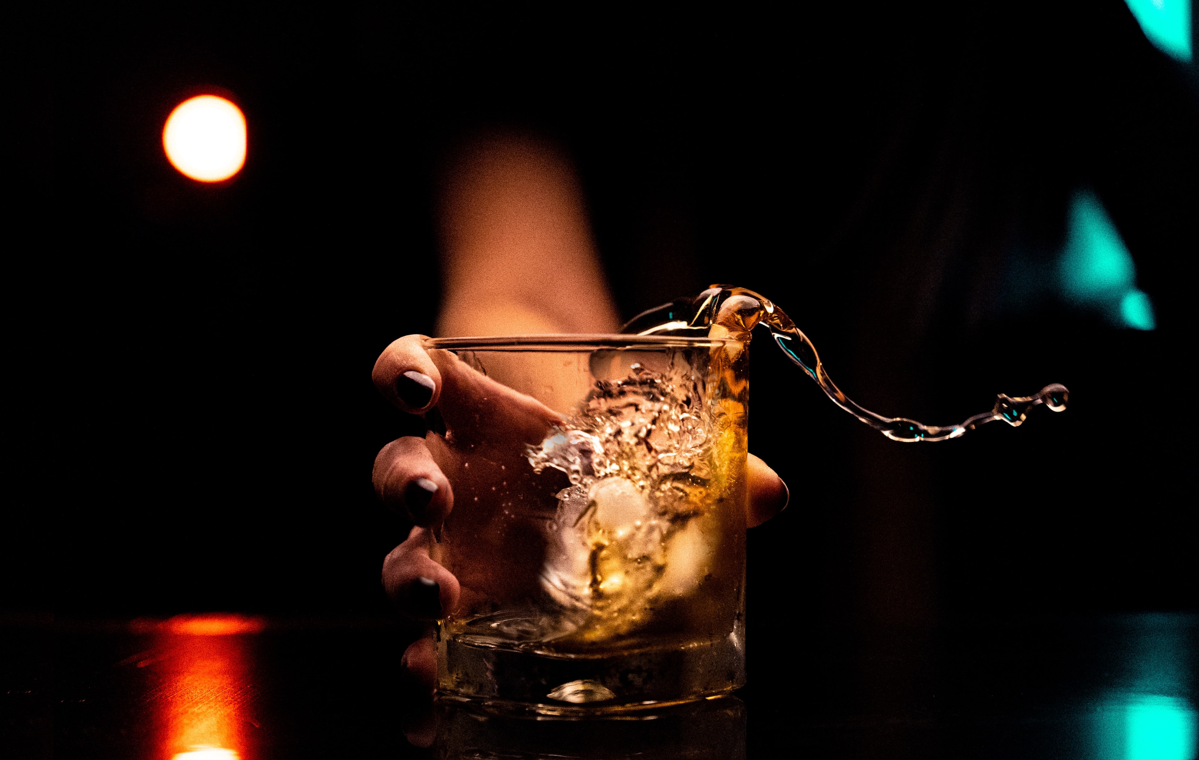 Whisky poured into a glass held by hand